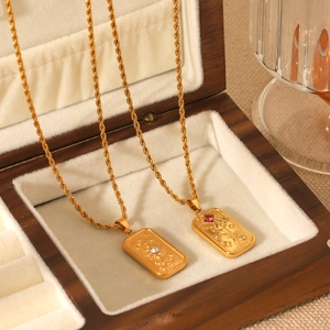 Gold tarot necklaces featuring sun and rose embossed pendants in a vintage jewelry box