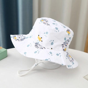 Detail of white cotton sun hat for kids featuring blue lion prints and adjustable chin strap