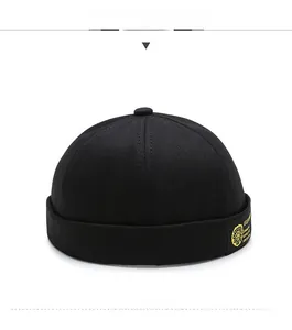 Side view of black cotton docker hat featuring detailed yellow silk embroidery patterns