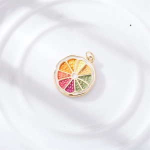 Detail of colorful citrus slice pendants with gold frames on a white ceramic plate