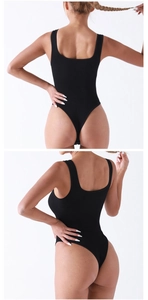 Macro detail of black ribbed fabric bodysuit showing seamless thong back and high cut design