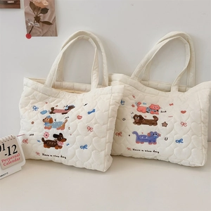 Détails de matelassage en cœur et broderies d'animaux sur des sacs à main blancs