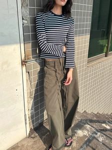Olive green drawstring wide-leg casual pants paired with a black and white striped sweater