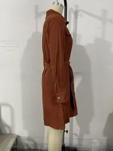 Detailed view of brown corduroy shirt dress featuring waist belt and metal cuff buttons