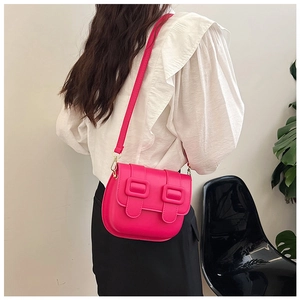 Détail d'un sac besace vintage rose fuchsia avec double boucles porté par un mannequin