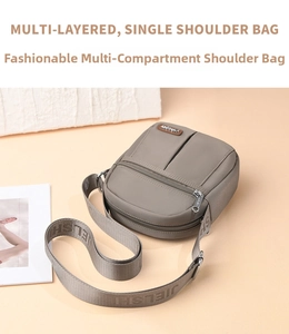 Detail of grey-brown waterproof nylon crossbody bag with multiple zipper pockets and wide strap