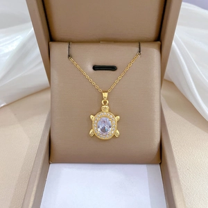 Elegant gold turtle pendant necklace with oval crystal and pavé stones in jewelry box