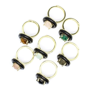 Set of 7 luxury faceted natural stone rings with black metal bands on white background