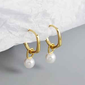 Macro shot of 925 silver stamp on gold earrings with white pearls and vintage style