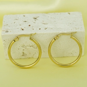 Detailed close-up of golden stainless steel hoop earrings with secure hinge closures