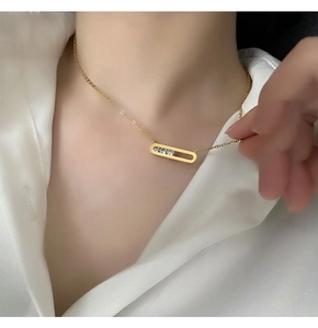 Close-up of 18K gold plated necklace with rectangular pendant and three zircons on model