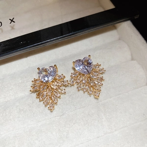 Close-up of gold flower earrings with heart-shaped zircon and marquise stones