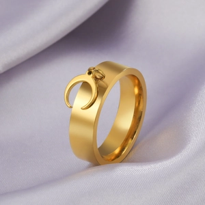 Detail of a gold minimalist ring with a crescent moon pendant on purple silk