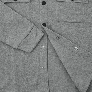 Close-up of grey marl casual jacket featuring black snap buttons and chest pocket detail