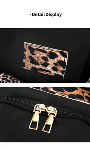 Detail showing high-density black nylon fabric with leopard print patch and gold zippers