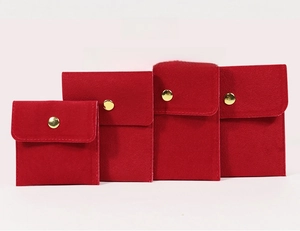 Détails de quatre pochettes à bijoux en velours rouge avec boutons-pression dorés