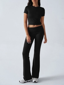 Detail of a two-piece black slim-fit set featuring short crop top and flare yoga pants