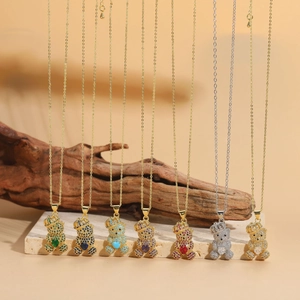 Gros plan de pendentifs d'ours avec couronnes en diverses couleurs de zircon sur bois et pierre