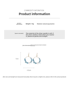 Detail view of large gold hoop earrings with blue aquamarine stones and white starfish