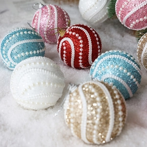 Boules de Noël scintillantes avec spirales de perles sur fond de neige multicolore