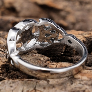 Detailed macro view of silver hollowed out ring with metal texture on wood background