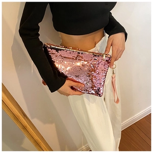 Close-up of pink sequin clutch bag with golden zipper and fabric wrist strap