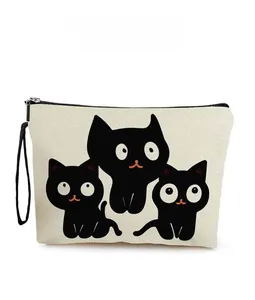 Close-up of printed cartoon cats on white canvas cosmetic bag with black zipper detail