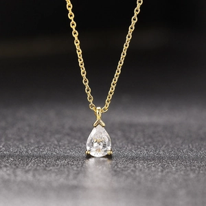 Macro shot of a pear-shaped cubic zirconia pendant on a 18k gold plated chain