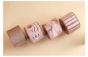 Detail of four festive pink gold ribbons featuring reindeer, snowflake and striped patterns
