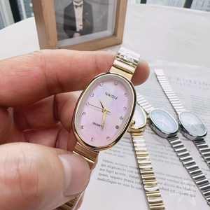 Detail of a gold quartz watch with an oval pink shell dial and rhinestone markers