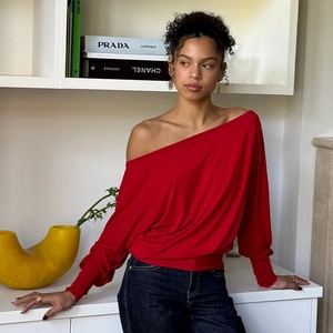 Detailed view of women's red off-shoulder long sleeve top with soft elastic fabric texture