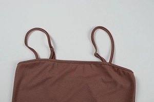Détail d'une robe marron montrant la bretelle réglable et la boucle en métal argenté