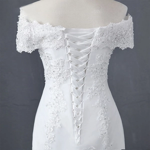 Detail eines eleganten weißen Spitzenbrautkleids mit silbernen Pailletten und Korsettrücken