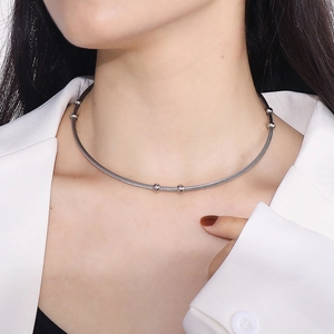 Detail of silver titanium steel wire collar with small beads shown on a model's neck
