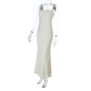 Detail shot of elegant white lace maxi dress with intricate floral embroidery and fishtail hem