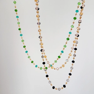 Macro shot of colorful faceted crystal beads and gold metal beads on titanium steel chain