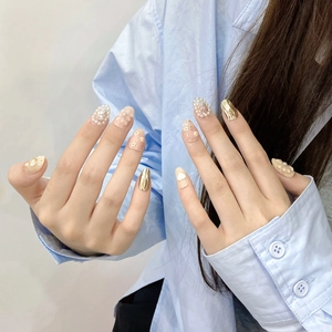 Faux ongles faits main avec fleurs en feuille d'or et perles sur base rose clair