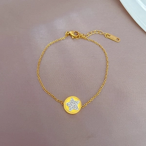 Detailed close-up of a gold titanium steel star pendant with cubic zirconia stones