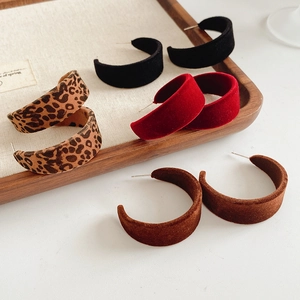 Detail of C-shaped flocked earrings in black, red, brown and leopard print patterns