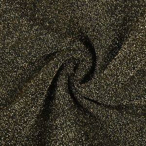 Macro di tessuto metallico nero e oro con una trama plissettata a spirale lucida