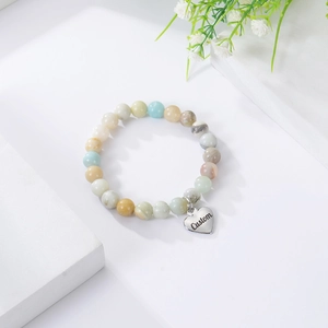 Detailed view of natural stone bead bracelet with a custom engraved heart pendant