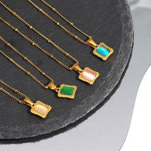 Vintage parfumflesje vierkante hangers in goud, set van vijf kettingen op grijze stenen plaat