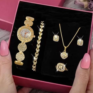 Close-up of luxury gold rhinestone watch, jewelry set and pink gift box presentation