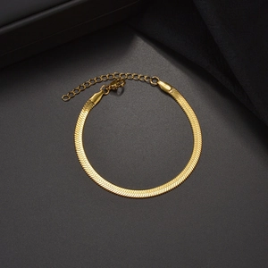 Golden 304 stainless steel flat snake chain bracelet with lobster clasp on grey surface