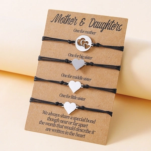 Detail of 4-piece mother and daughters bracelets set with silver heart charms on card