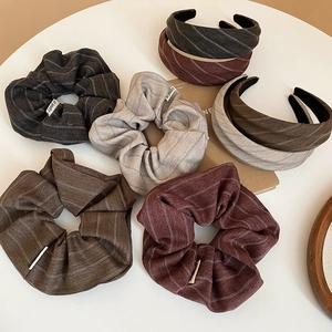 Detail of fabric scrunchies and headbands featuring textured herringbone patterns and colors