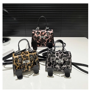 Detailed view of three mini leopard print crossbody bags with cute anthropomorphic designs