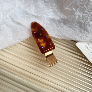 Detail of tortoise shell acrylic duckbill hair clip with colorful crystal rhinestones