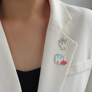 Cool cartoon tooth enamel pins with unicorn and doctor designs on white suit lapel