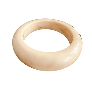 Minimalist resin bangle with amber texture in creamy white on a clean white background